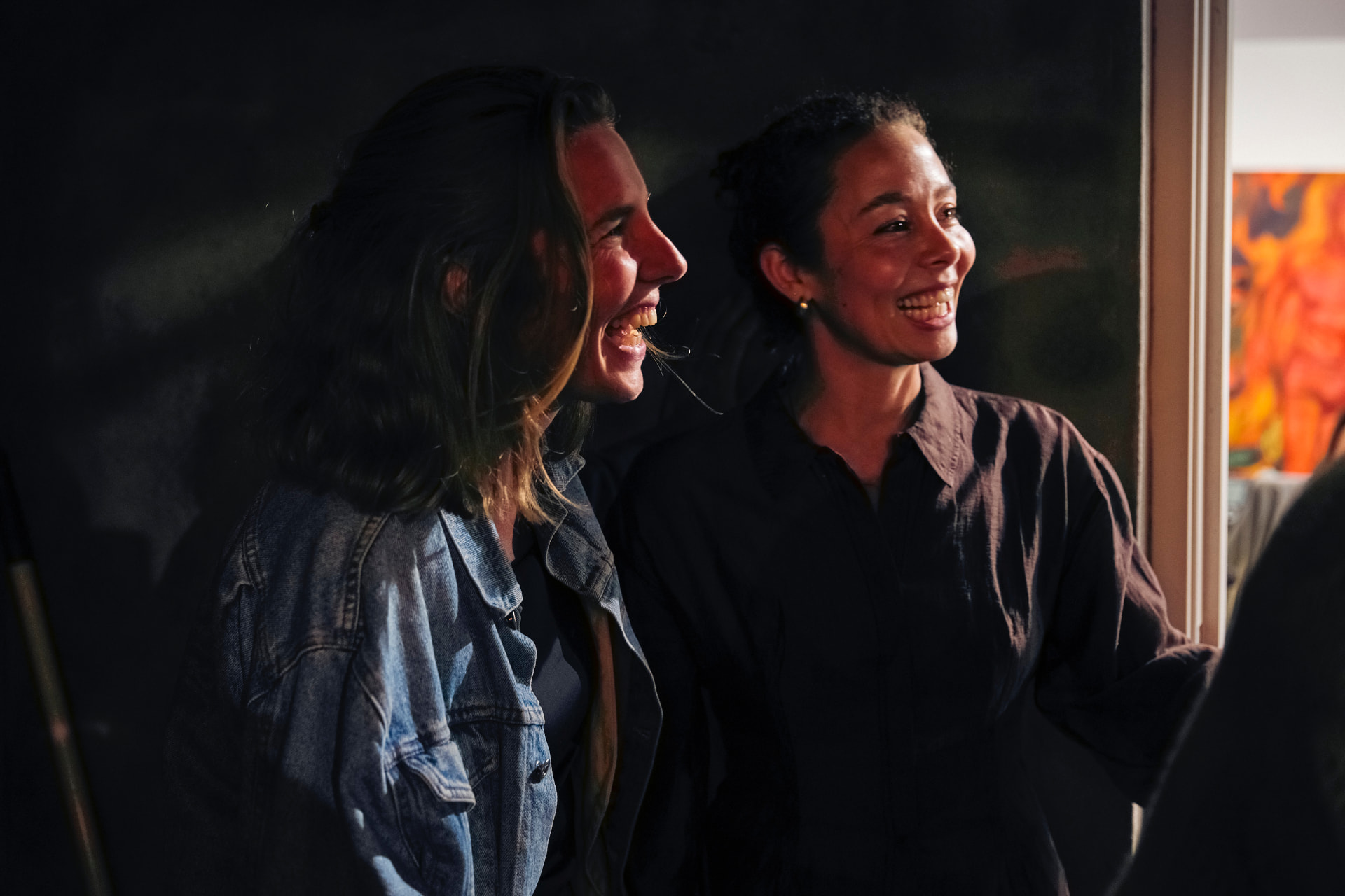 Twee lachende bezoekers in het donker bij een schilderij