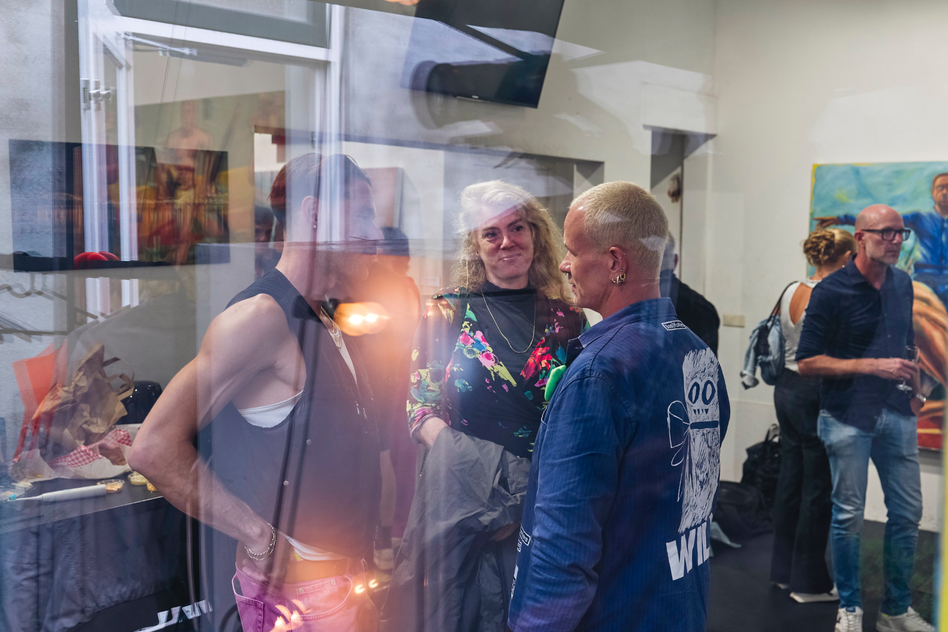 Bezoekers in gesprek, weerspiegeld in glas